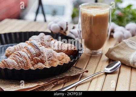 Petit-déjeuner français - croissants avec un verre de latte à l'extérieur.matin esthétique. Banque D'Images