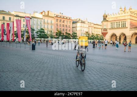 Cracovie, Pologne - 25 août 2022 : un messager Glovo non identifié dans la rue de Cracovie, en Pologne. Livraison de nourriture, de produits Banque D'Images