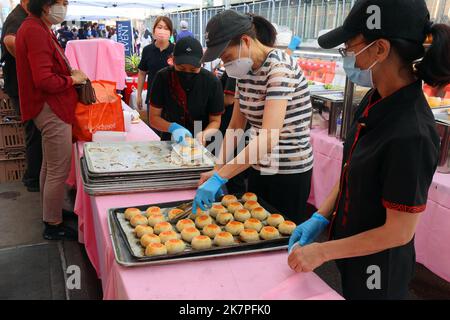Les ouvriers de Shanghai You Garden servent des gâteaux de porc 鮮肉月餅 fraîchement cuits et croustillants dans une foire de rue à l'extérieur de leur restaurant à Flushing, New York. Banque D'Images