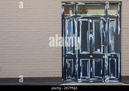 Une porte en bois d'époque noire avec raccords en laiton est prête pour la peinture Banque D'Images