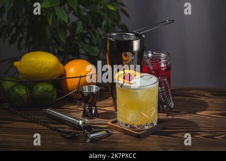 Cocktail au whisky dans un verre à l'ancienne avec gouttes d'eau sur la table dans la maison. Nouveau concept de la quarantaine de la vie. Gros plan, faible profondeur du fi Banque D'Images