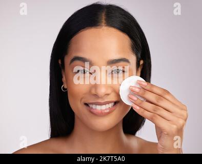 Pas de pores obstrués ici. Portrait court d'une jeune femme attrayante exfoliant son visage sur fond rose. Banque D'Images