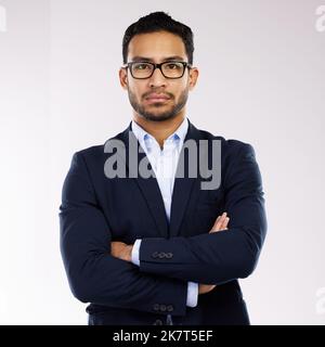 Un entrepreneur réussi a toujours un fort sentiment de confiance en soi. Portrait studio d'un jeune homme d'affaires confiant debout avec ses bras Banque D'Images