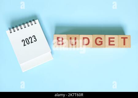 Budget de l'année 2023 et concept de budgétisation. Le calendrier du bureau est posé à plat sur fond bleu. Banque D'Images