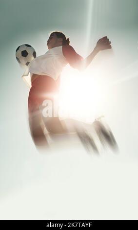 Joueur de football, ballon de poitrine et saut dans le ciel bleu, le soleil ou l'entraînement en plein air pour le match, le football ou le jeu. Santé, énergie et homme de l'Inde saut Banque D'Images