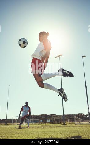 Football, sport et entraînement avec un homme athlète jouant avec un ballon sur un terrain ou terrain pour l'exercice et la remise en forme. Football, saut et entraînement