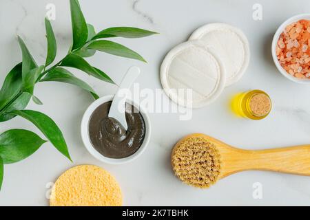 Masque en argile fait maison pour le visage et le corps dans un bol blanc à côté d'éponges assorties. Tampons lufa réutilisables pour le retrait du masque et la compression du visage pour les masagi sèches Banque D'Images