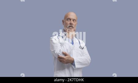 Médecin senior posant et pensant, médecine et concept de soins de santé Banque D'Images