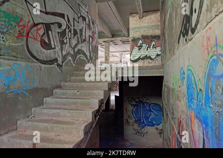 Escalier dans la ruine abandonnée, murs aspergés de graffiti Banque D'Images