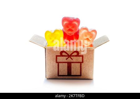 Friandises de fête concept : bonbons colorés en gélatine forme d'ours dans une boîte cadeau en carton isolée sur fond blanc. Banque D'Images