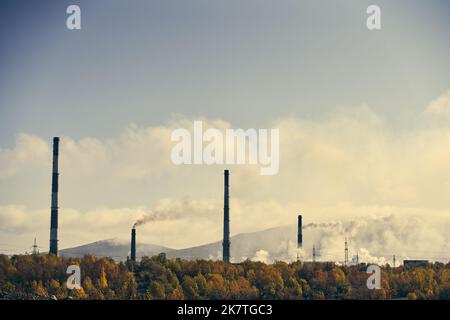 Paysage industriel avec une forte pollution produite par une grande usine. Tuyaux sur le territoire de l'usine. Banque D'Images