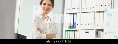 Présentable employée fille posant assis sur le bureau dans le bureau, look élégant pour le travail Banque D'Images