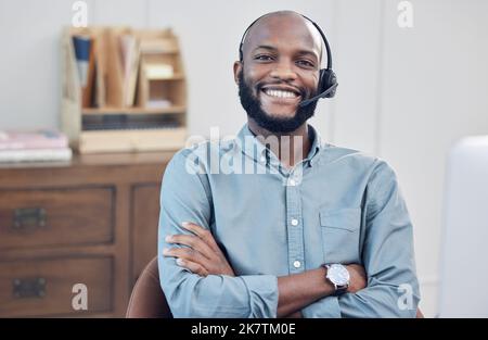 C'était une journée réussie. un beau jeune homme d'affaires assis seul dans son bureau avec ses bras repliés tout en portant un casque. Banque D'Images
