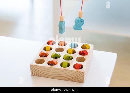 Les enfants jouent et trouvent le nombre correspondant dans le jeu de pêche magnétique en bois, en utilisant le poteau de pêche en bois fourni avec des aimants pour fixer le protocole d'entente Banque D'Images