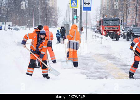 Russie Moscou 13.02.2021 fortes chutes de neige, neige hiver effondrement, blizzard dans la ville.équipe de concierges en uniforme nettoie la route, trottoir piétonnier sur la rue,r Banque D'Images