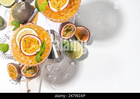 Cocktail de martini aux fruits de la passion. Boisson alcoolisée au pornstar sucré avec fruits de la passion frais et citron vert, avec ustensiles de bar Banque D'Images