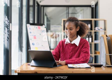 Jeunes afro-américains travaillant à l'intérieur d'un ordinateur à la maison ou au bureau Banque D'Images