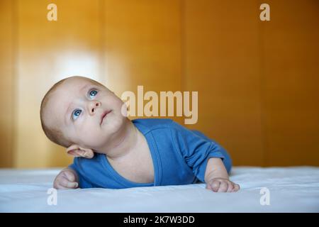 bébé de 4 mois avec les yeux bleus regardant vers le haut Banque D'Images