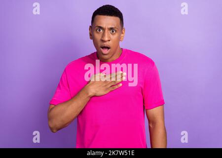 Portrait photo de jeune choqué gars toucher poitrine paume honnête réaction inattendue surprise mécontent mauvaises nouvelles des médias sociaux isolés sur la couleur violette Banque D'Images