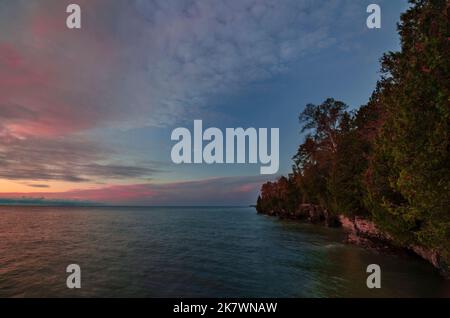 Le ciel au-dessus de la rive du lac Michigan s'illumine avec une brève couleur de lever du soleil au parc du comté de Cave point, comté de Door, Wisconsin Banque D'Images