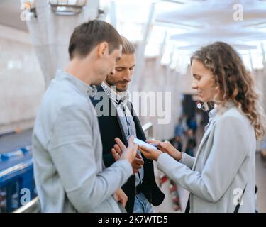les jeunes gens d'affaires discutent de nouvelles informations à la station de métro . Banque D'Images