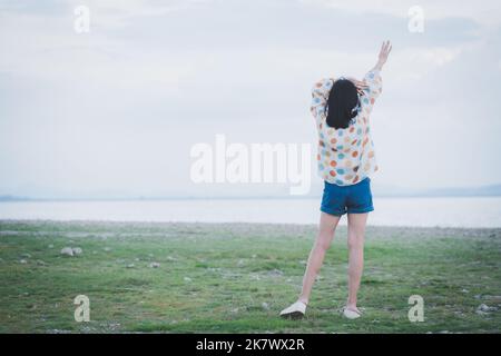Femme heureuse debout avec les bras étendus et appréciant la vie de plage à la mer. Voyage et vacances, happy time Banque D'Images