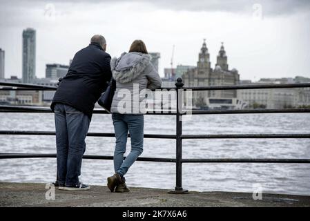 Un couple contemplez la rivière Mersey au bâtiment Royal Liver sur le front de mer depuis la Seacombe. Banque D'Images