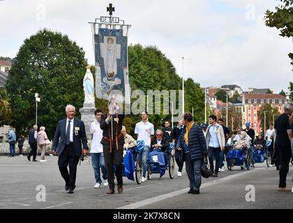 Lourdes, Hautes-Pyrénées, France. Soignants avec pèlerins en fauteuil roulant Banque D'Images