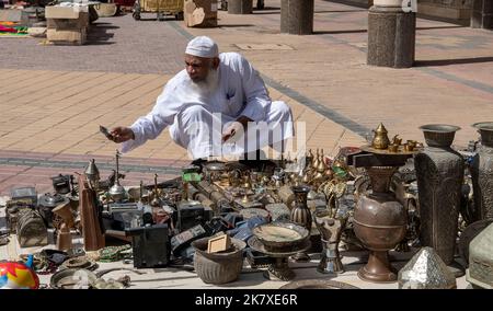 Homme arabe inspectant le marché aux puces de bric-a-brac Riyad Arabie Saoudite Banque D'Images