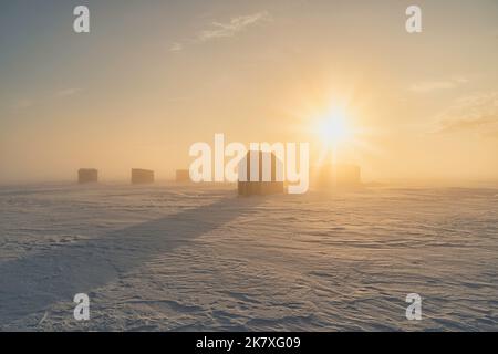 Pêche sur glace dans un port gelé dans la région rurale de l'Île-du-Prince-Édouard, Canada. Banque D'Images