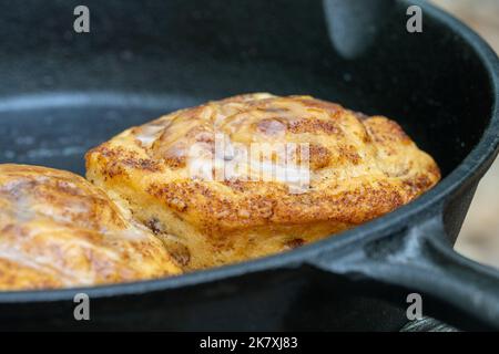 petits pains à la cannelle cuits dans une casserole en fonte à l'extérieur sur un feu Banque D'Images