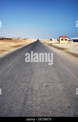 Route désertique asphaltée vide, mise au premier plan, virage de couleur appliqué, Egypte. Banque D'Images