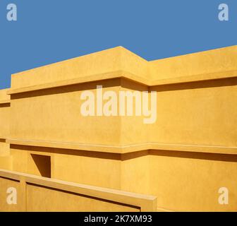 Mur de bâtiment jaune contre le ciel bleu. Banque D'Images