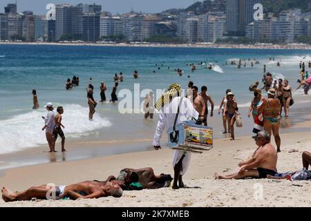 Vendeurs de nourriture de rue à pied à la plage de Copacabana. Des promenades d'hommes vendant des marchandises aux Beach-pêcheurs près de la rive - Rio de Janeiro, Brésil Banque D'Images