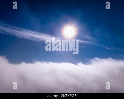 Photo aérienne au-dessus des nuages avec halo autour du soleil, ciel clair au-dessus du paysage blanc en mouvement rapide Banque D'Images