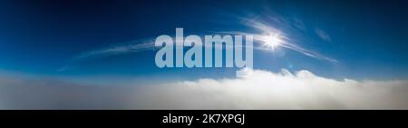 Grand panorama photo aérienne au-dessus des nuages avec le soleil, ciel clair au-dessus du paysage blanc en mouvement rapide Banque D'Images