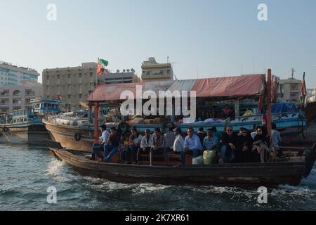 Les gens font un trajet en Abra, un bateau-taxi traditionnel qui traverse la crique de Dubaï d'Al Ghubaiba à Deira et vice versa. Paysage urbain du vieux Dubaï avec bateaux. Banque D'Images