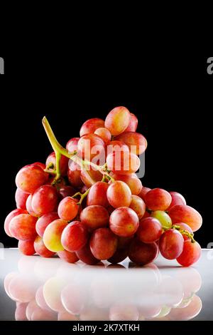 Bouquet brillant de raisins rouges mûrs isolés sur fond noir et blanc Banque D'Images