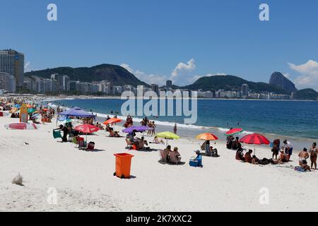 Plage de Copacabana, Rio de Janeiro, Brésil. Les gens se bronzent près de la mer, parasols colorés. La foule aime nager en été. Lieu de voyage tropical Banque D'Images