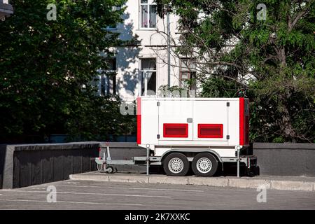 Générateur de secours blanc et rouge sur la remorque avec roues. Générateur d'urgence mobile ou générateur de secours - équipement électrique extérieur sur la rue ne Banque D'Images