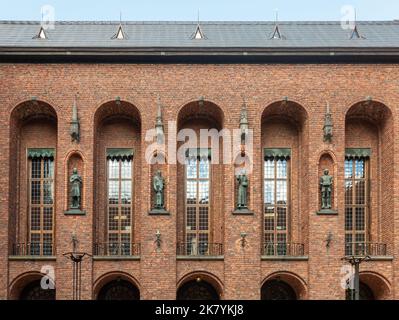 Suède, Stockholm - 16 juillet 2022: Hôtel de ville ou Stadshuset. 4 statues de bronze se trouvent dans des niches sur la façade sud en brique de la cour entre le vent mince Banque D'Images