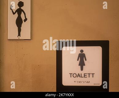 Suède, Stockholm - 16 juillet 2022 : panneau de toilette féminin avec 2 pictogrammes et texte, même en braille Banque D'Images