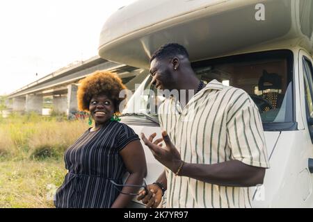 Adorable couple hétérosexuel noir. Amis, voyageurs et proches. Portrait en plein air de deux personnes ayant une conversation positive sur leur prochain voyage à travers l'Europe. Durée de vie de la fourgonnette. Photo de haute qualité Banque D'Images