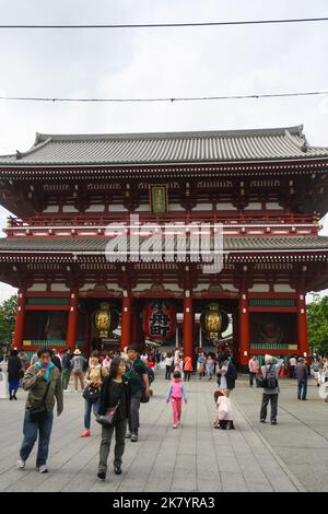 Vue sur la porte Hozomon à l'intérieur du complexe du temple Sensoji avec une foule de personnes marchant et des nuages dans un ciel lumineux. Banque D'Images