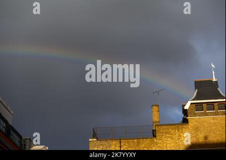 LONDRES - 2 novembre 2020: Arc-en-ciel contre un ciel sombre de tempête au-dessus des toits de Whitechapel Banque D'Images