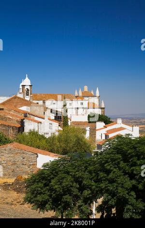 Maisons au toit en terre cuite et église à l'intérieur de l'ancien château de Monsaraz, Portugal. Banque D'Images