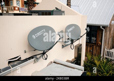 Deux antennes de télévision par satellite (TV) pour Direct TV placées sur le côté d'un bâtiment à Harborwalk Village et Marina à destin Florida, USA. Banque D'Images