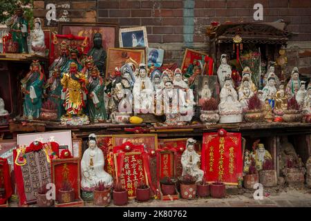 Statuettes de dieux chinois exposées contre le mur extérieur du Temple Tin Hau, Yau Ma Tei, Kowloon, Hong Kong Banque D'Images