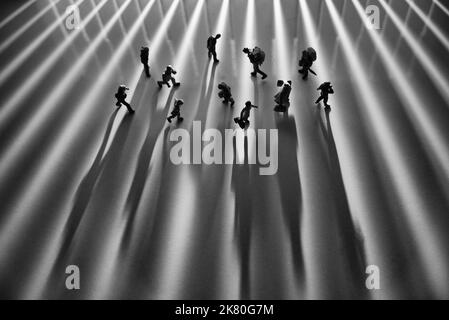 Miniature People Toys studio Set up - vue du dessus de l'effet noir et blanc des personnes avec de longues ombres occupé à marcher pendant le lever ou le coucher du soleil. Bruit adde Banque D'Images