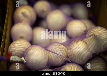 Ail dans le filet. Oignons sur le marché. Vente de plantes racines. Détails de la nourriture. Produits naturels. Banque D'Images